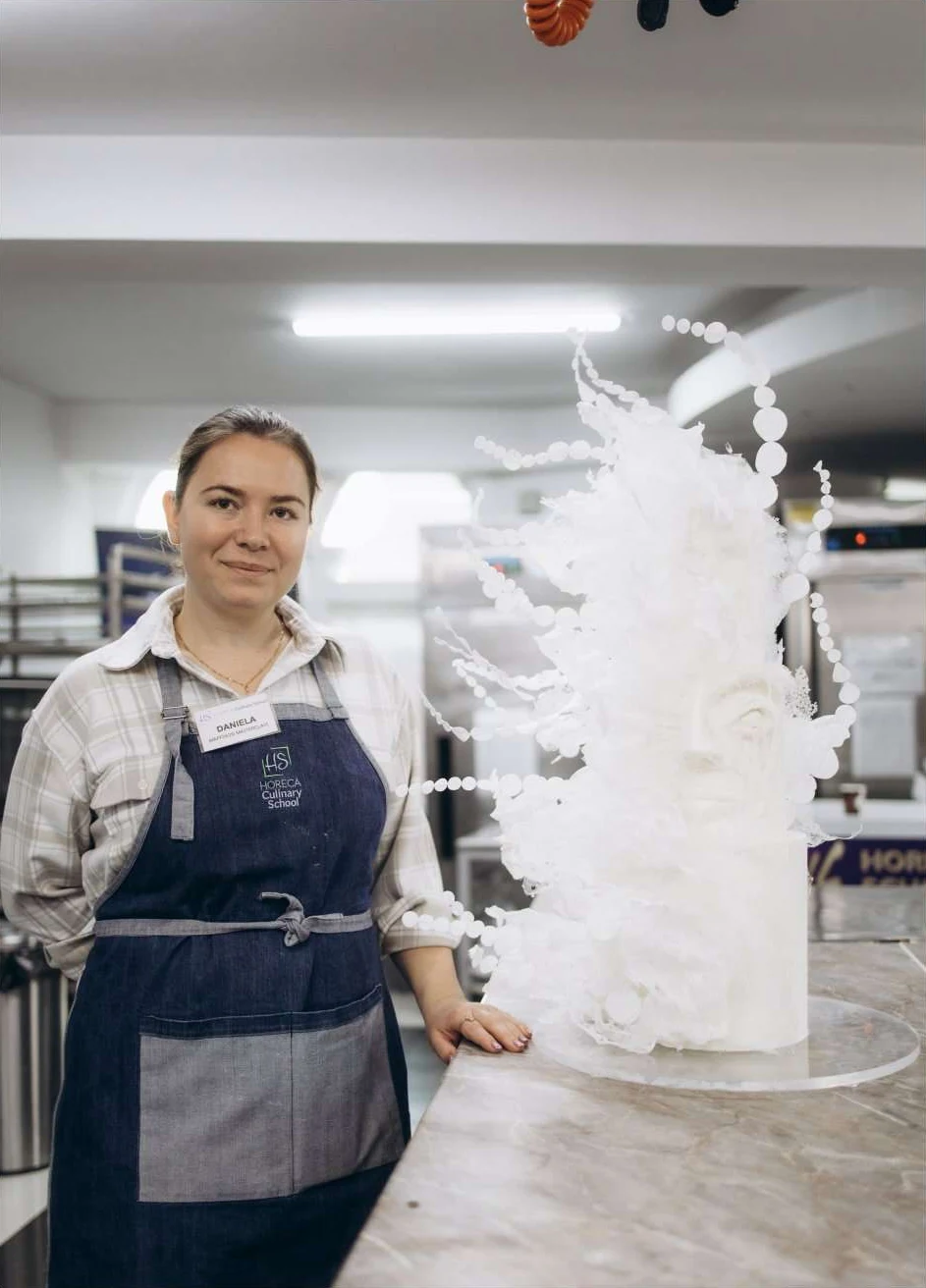 Aleina, the baker, standing next to one of her wedding cakes